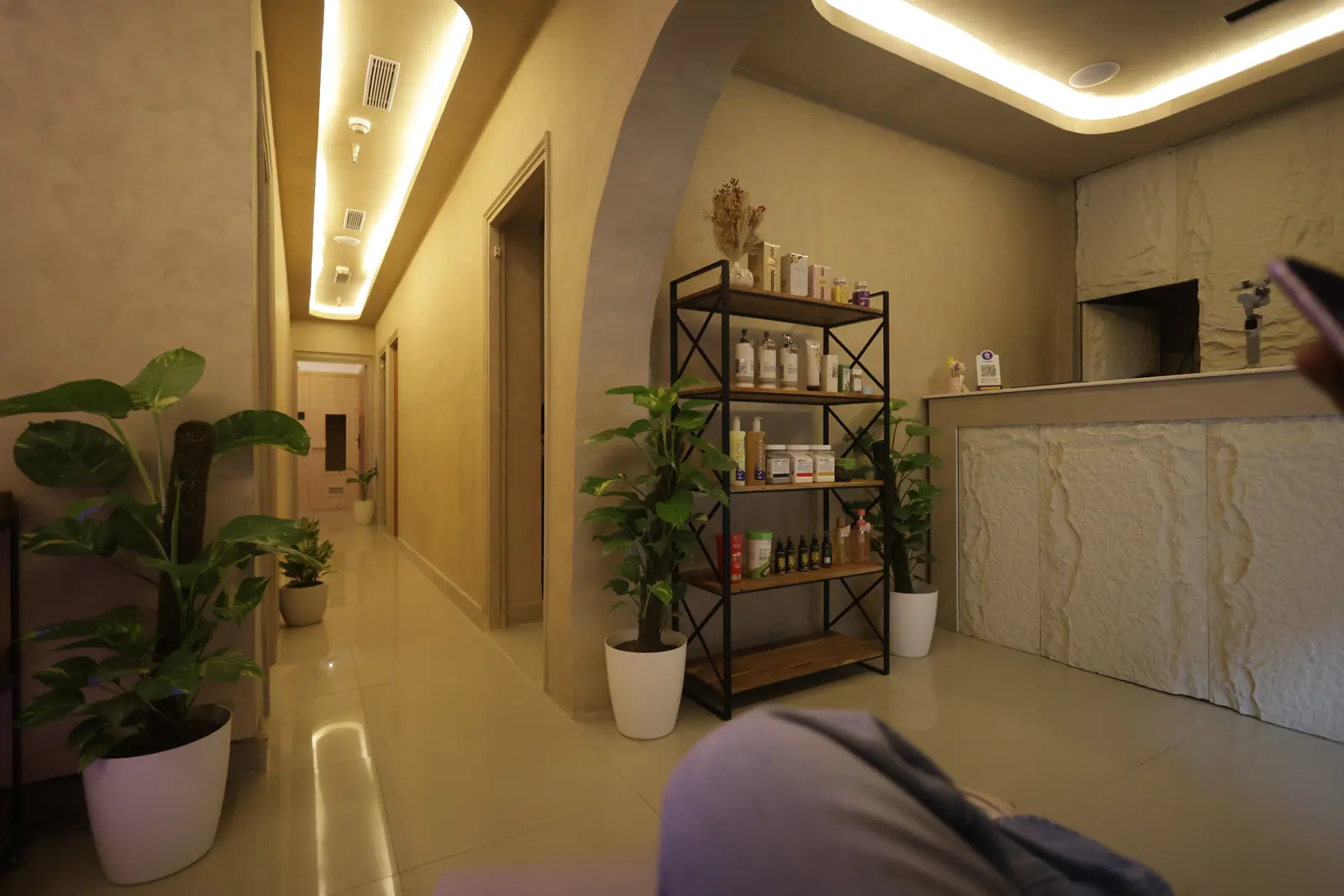 View along the entry corridor toward the reception desk at Maris & Terra luxury spa, Noida